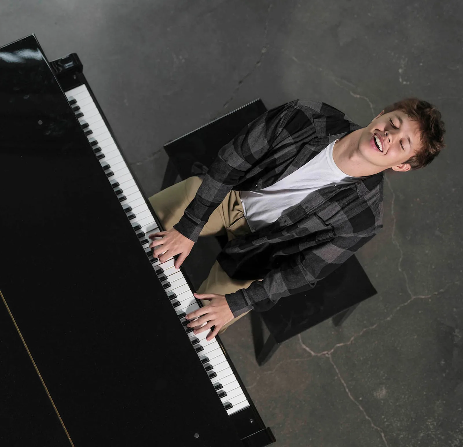 Overhead view of Max Cooper III leaning back from a grand piano